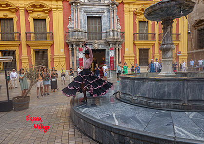 Une belle jeune fille dansant la sevilla au péron de la Cathédrale de Malaga pour le plaisir des touristes nombreux